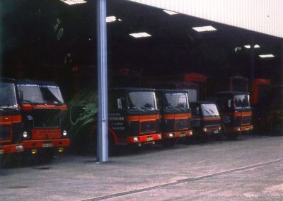 Rangée de camions garés à l'intérieur d'un entrepôt.
