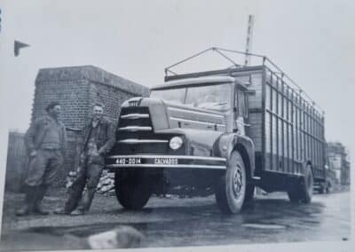Francis Roselier, debout près d'un camion, à ses tout débuts dans le transport routier.